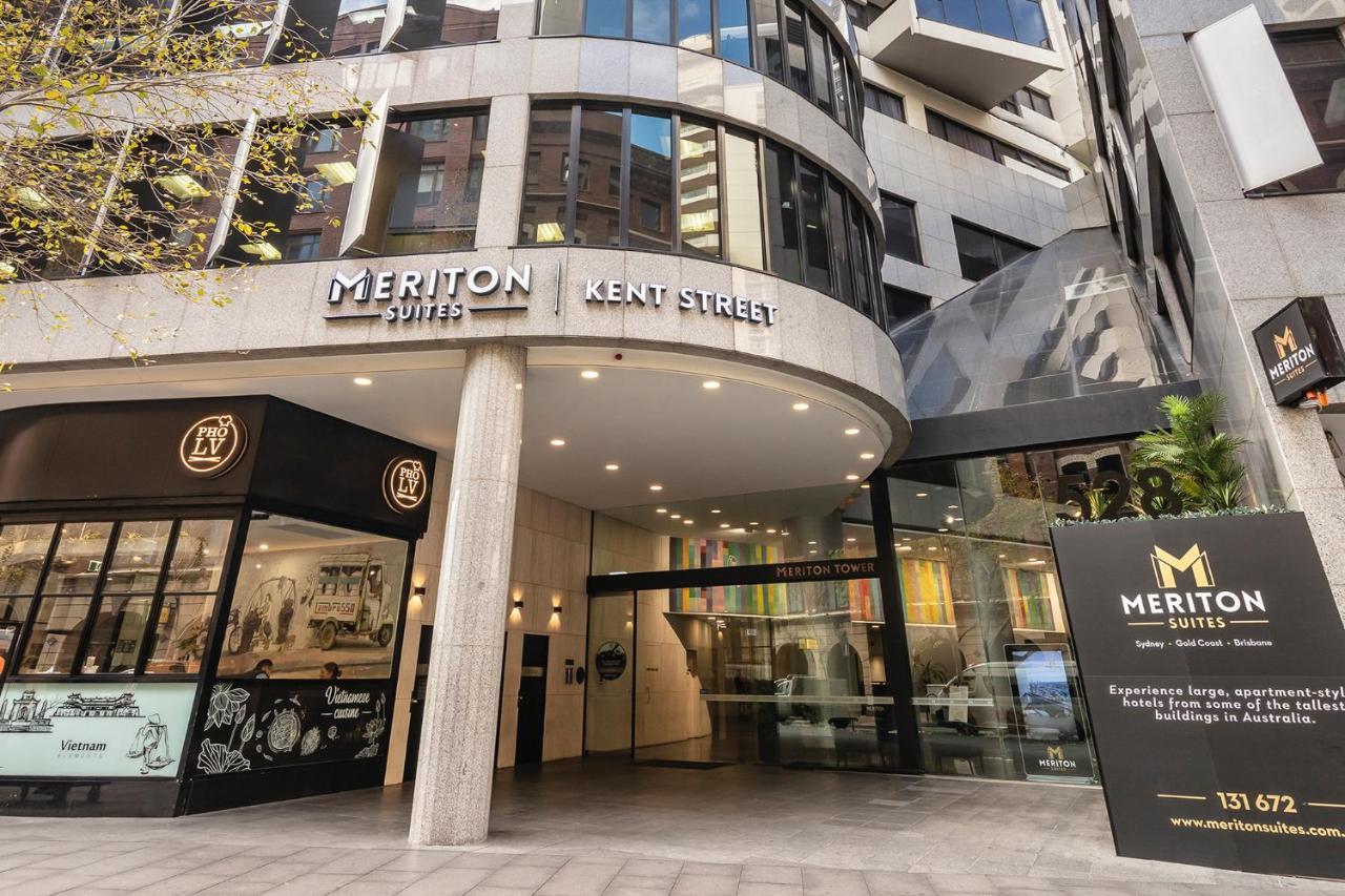 Meriton Suites Kent Street, Σίδνεϊ Εξωτερικό φωτογραφία The photo shows the entrance of the Meriton Suites located on Kent Street. The building features a modern design with a glass facade and prominent signage displaying the name "Meriton Suites." There is also a large sign near the entrance with additio